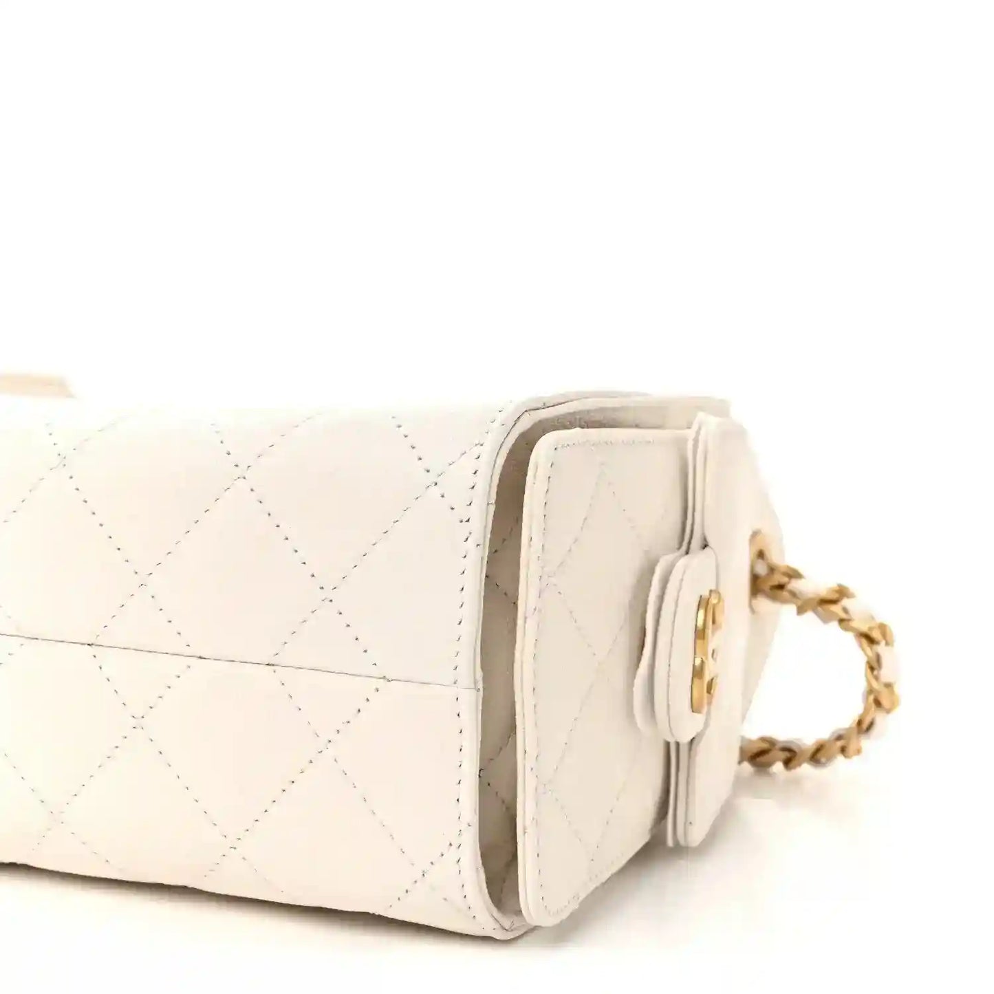 White quilted leather mini handbag angled side view with flap pocket and gold-tone chain strap