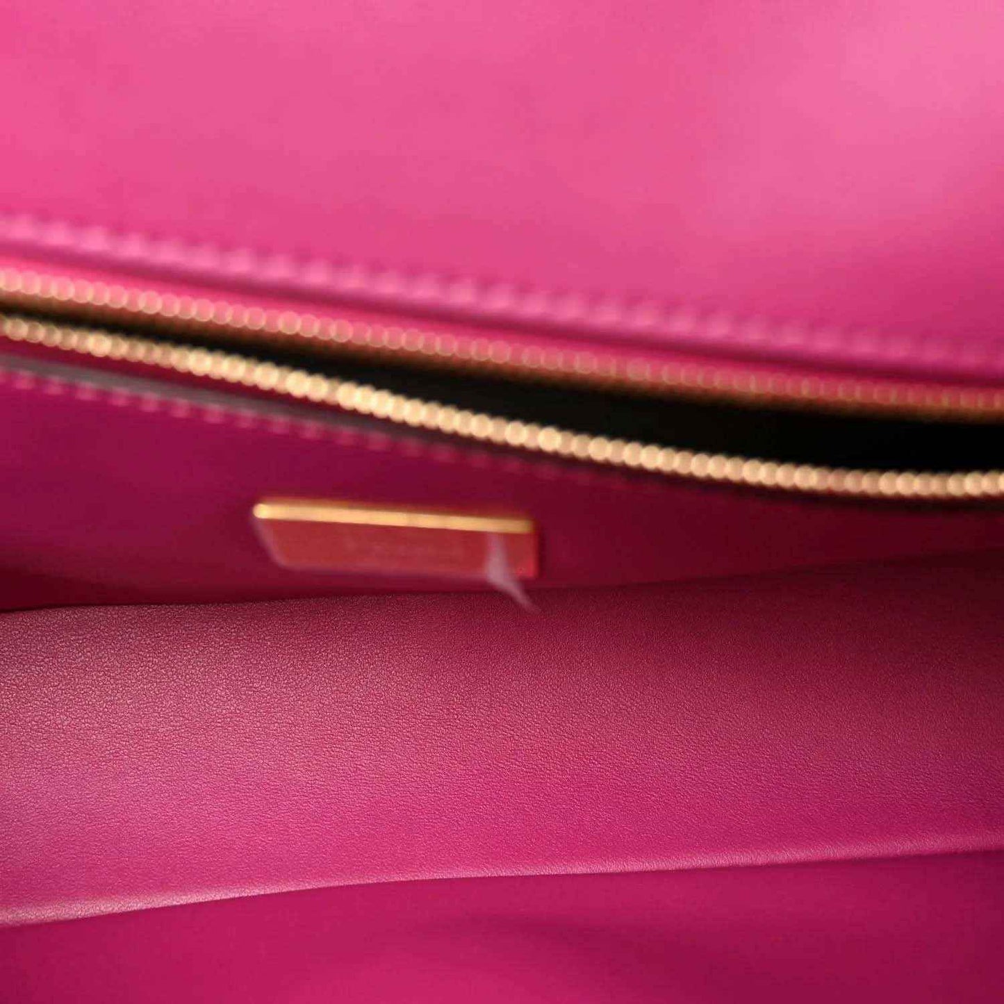 Pink leather baguette interior with gold-tone hardware and visible stitching