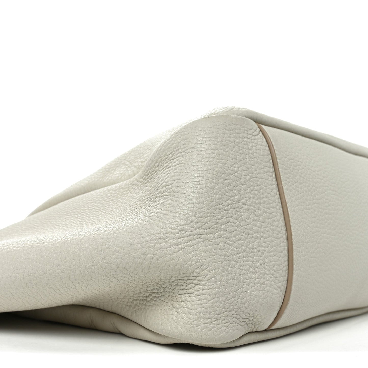 Close-up of white grained leather tote bag side with smooth curved panel