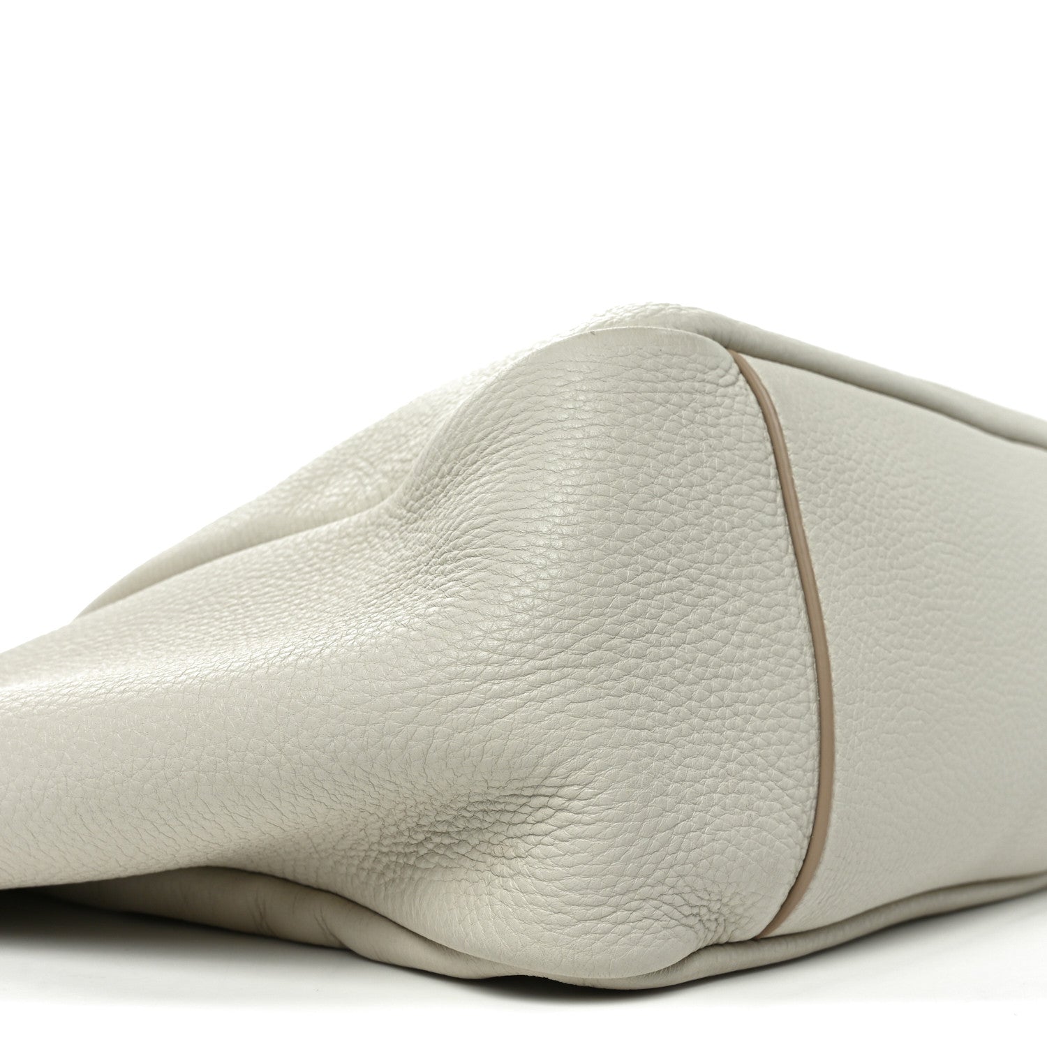 Close-up of white grained leather tote bag side with smooth curved panel
