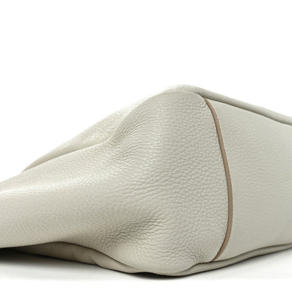 Close-up of white grained leather tote bag side with smooth curved panel