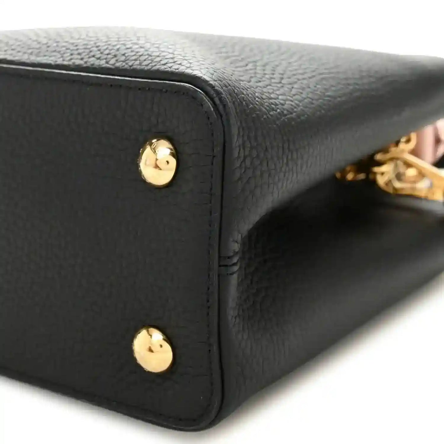 Black leather handbag corner with gold stud and close-up stitched edge