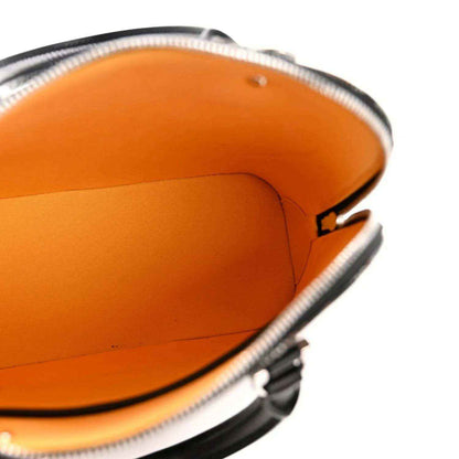 Mini bag interior with bright orange lining and zippered opening, showing leather trim