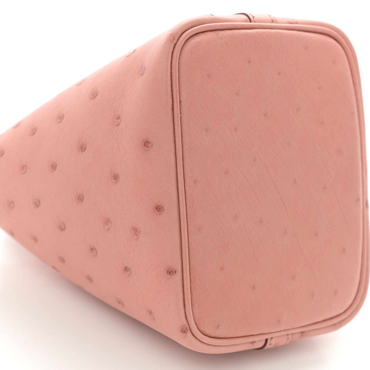 Light pink ostrich leather mini bucket bag with rounded sides and top cover