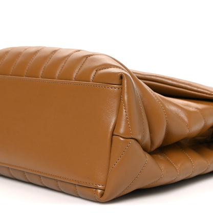 Tan leather satchel corner with quilted panels and zipper track detail