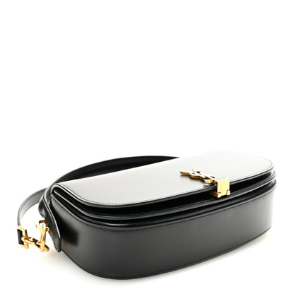 Bicolor crossbody bag with white flap and black body, top clasp with YSL initials.