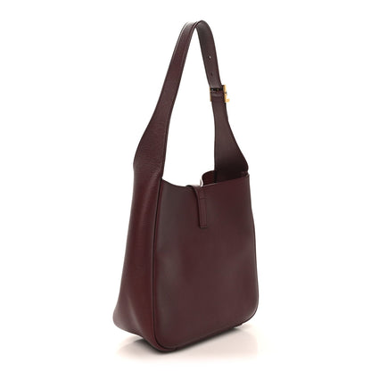 Burgundy leather shoulder bag with wide straps and structured rounded base