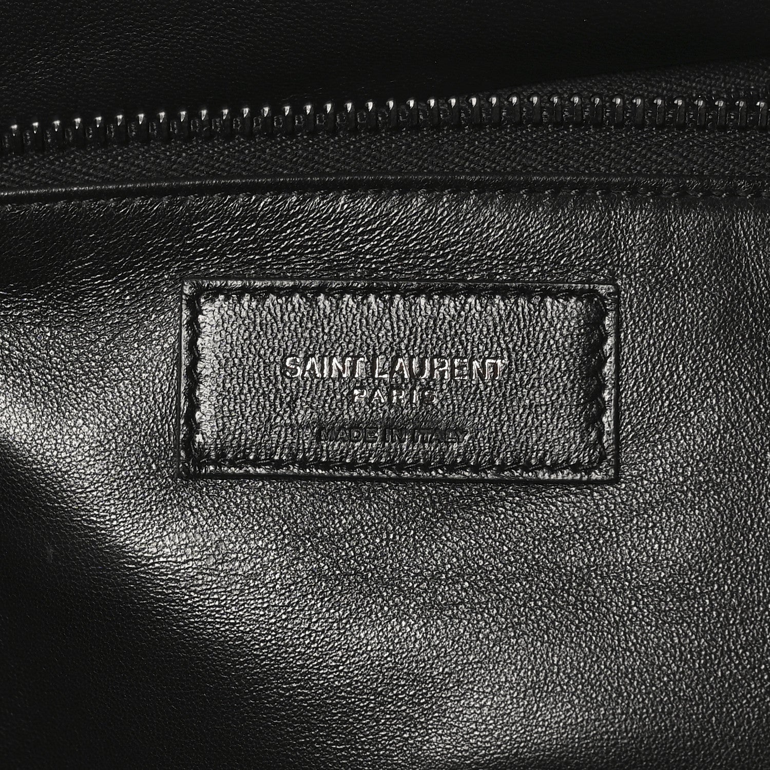 Black leather tote interior label with SAINT LAURENT PARIS branding and stitching.