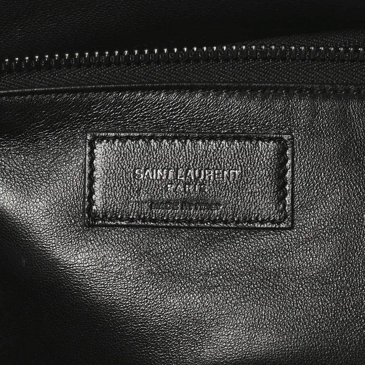 Black leather tote interior label with SAINT LAURENT PARIS branding and stitching.