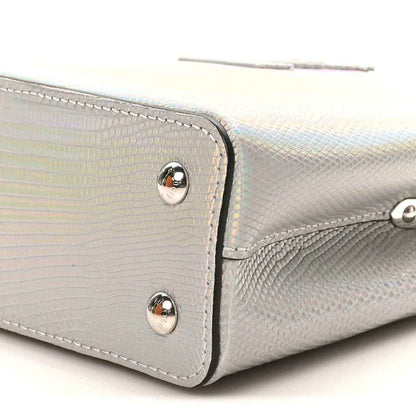 Iridescent lizard mini handbag side close-up with silver rivets and curved trim