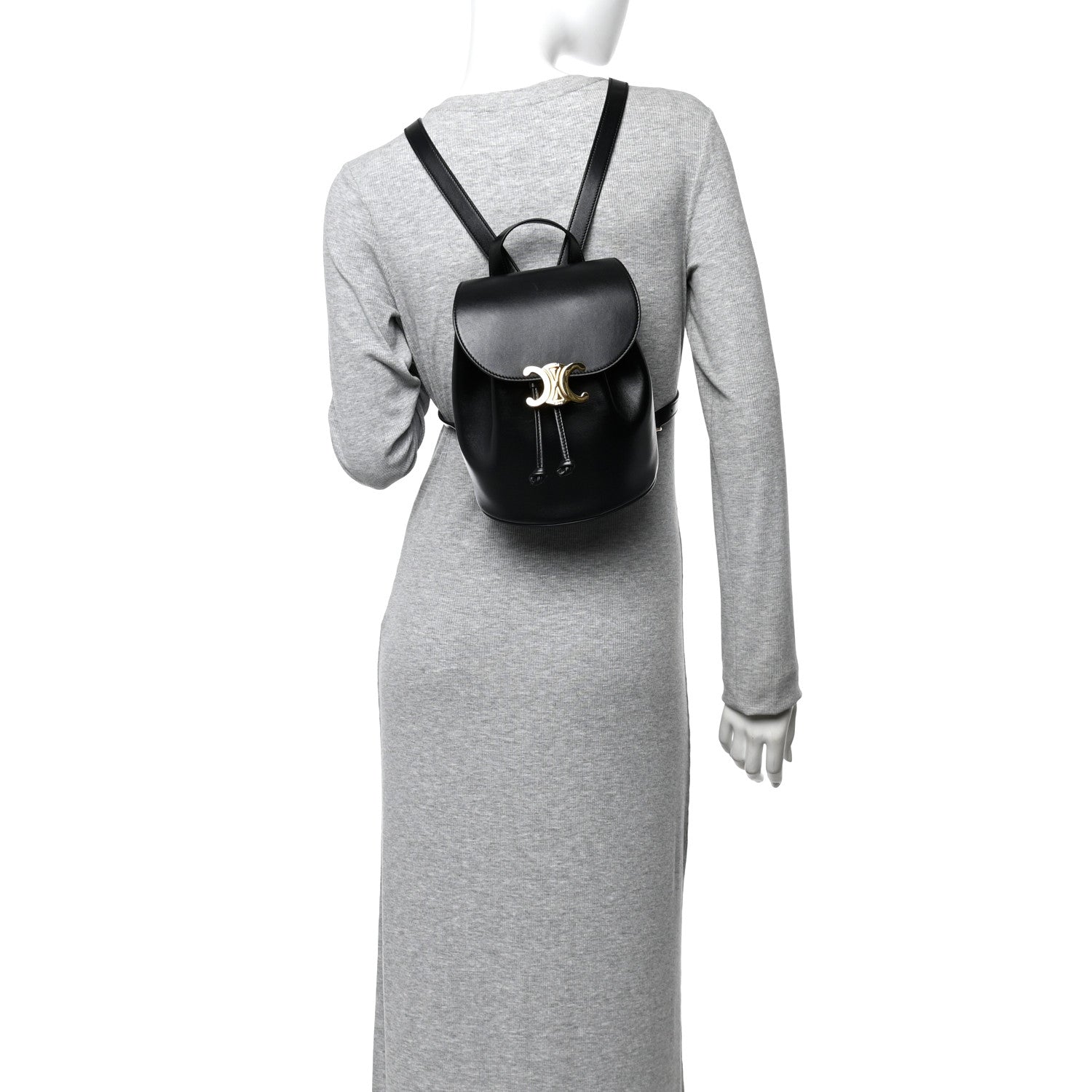 Celine Triomphe calfskin Bonnie backpack, black, worn over a long-sleeve dress.