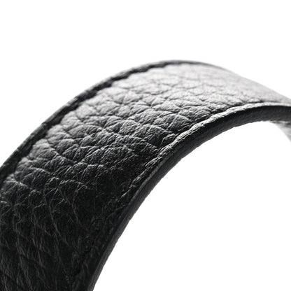 Black pebbled leather tote handle close-up with curved edge