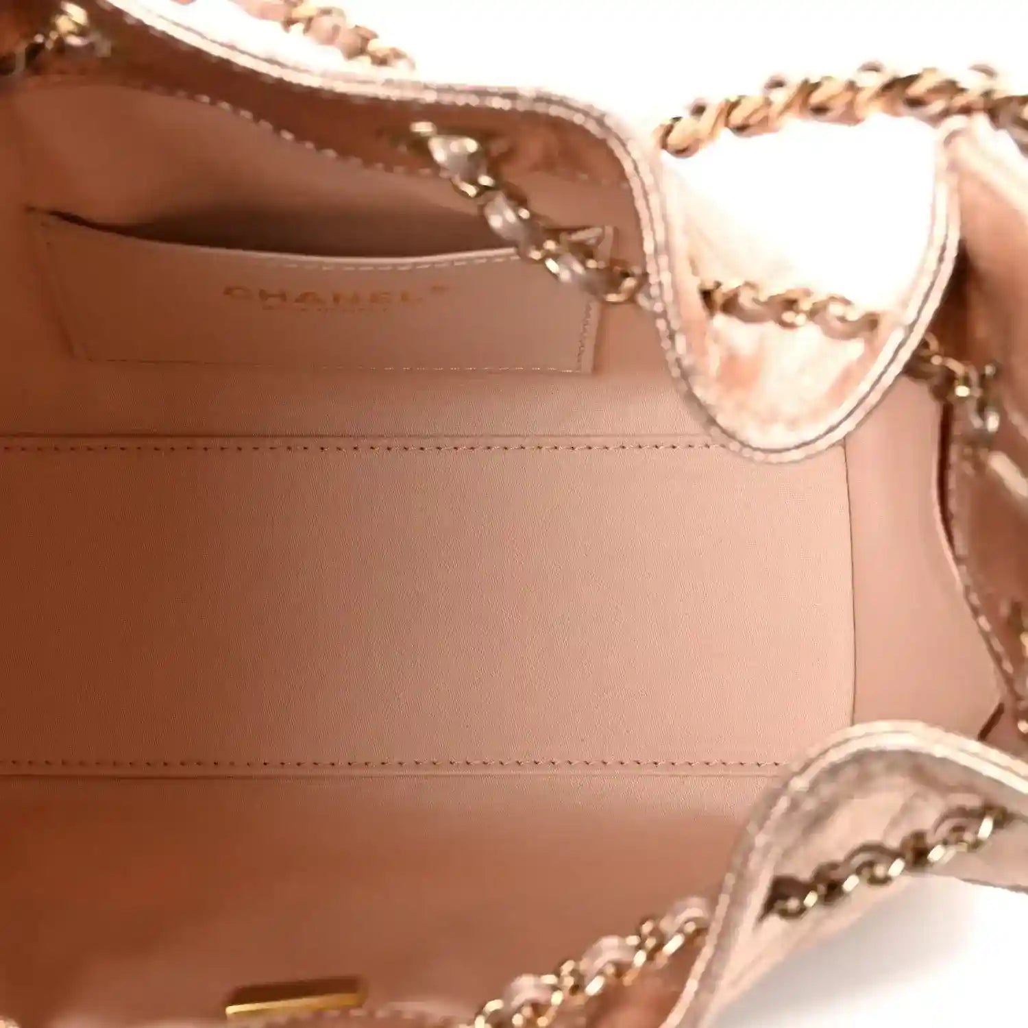 Copper quilted mini handbag interior view with stitched lining and chain hardware.