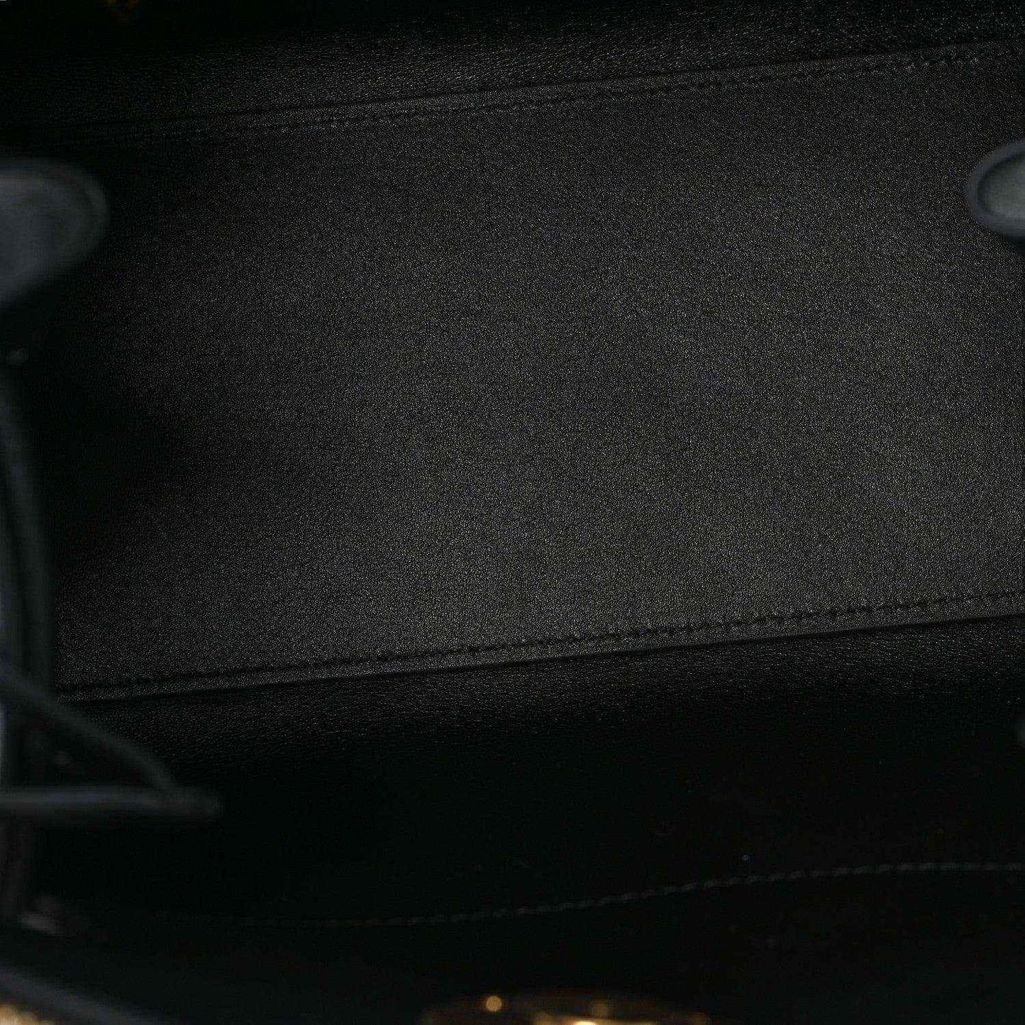 Black fabric lining inside a small leather handbag