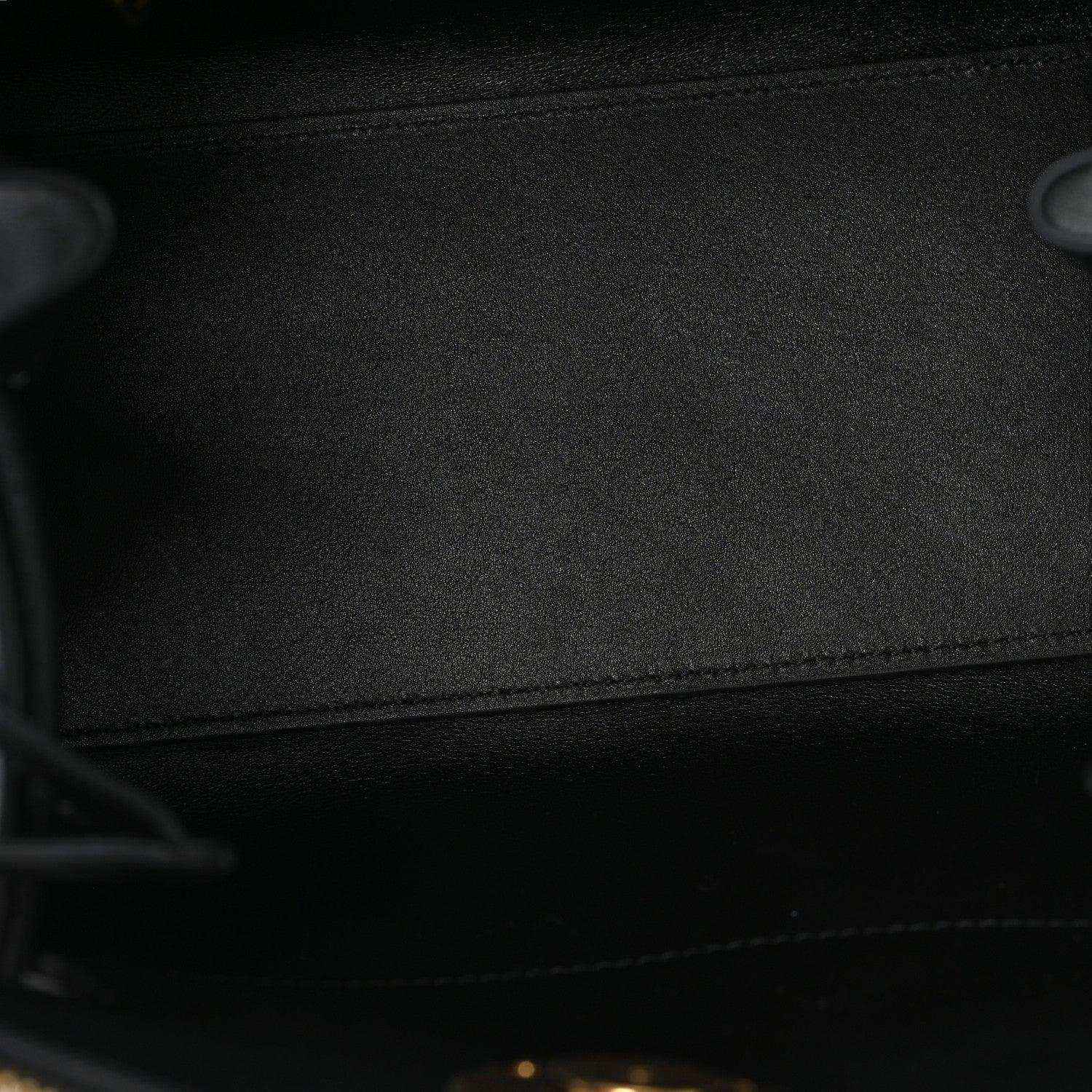 Black fabric lining inside a small leather handbag