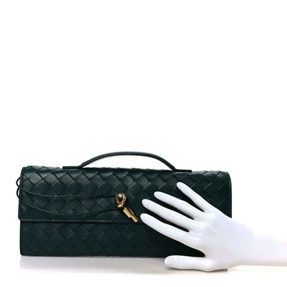 Emerald green intrecciato nappa long clutch bag with top handle and gold clasp, shown by hand