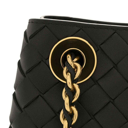 Black woven leather bag with gold-tone round clasp and linked chain strap