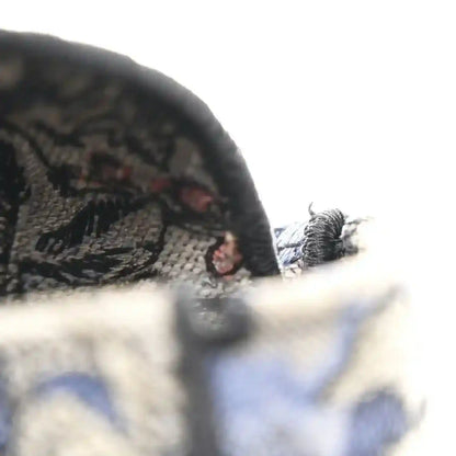 Embroidered denim bag side with black zipper pull and tassel