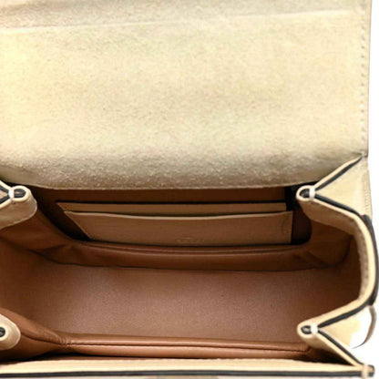 White mini handbag interior with brown lining and side snap pocket panels