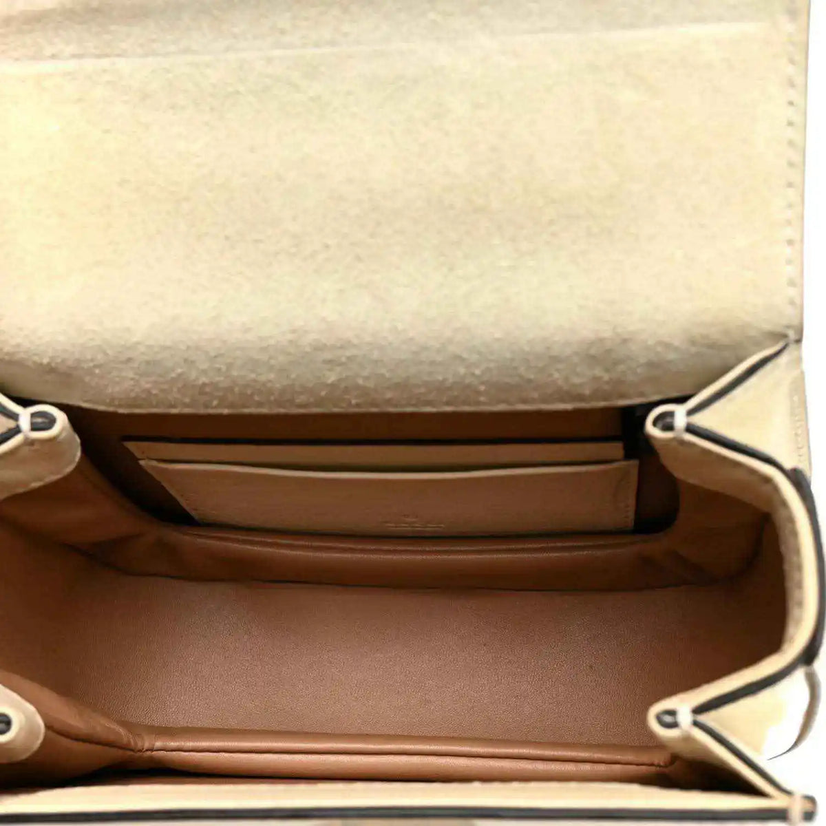 White mini handbag interior with brown lining and side snap pocket panels