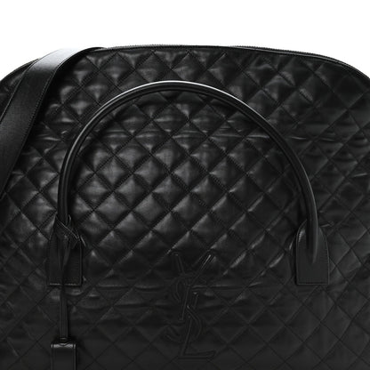 Black quilted leather travel bag with curved handle and embossed monogram on front