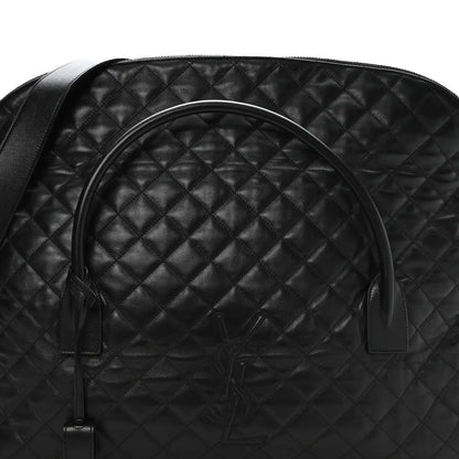 Black quilted leather travel bag with curved handle and embossed monogram on front