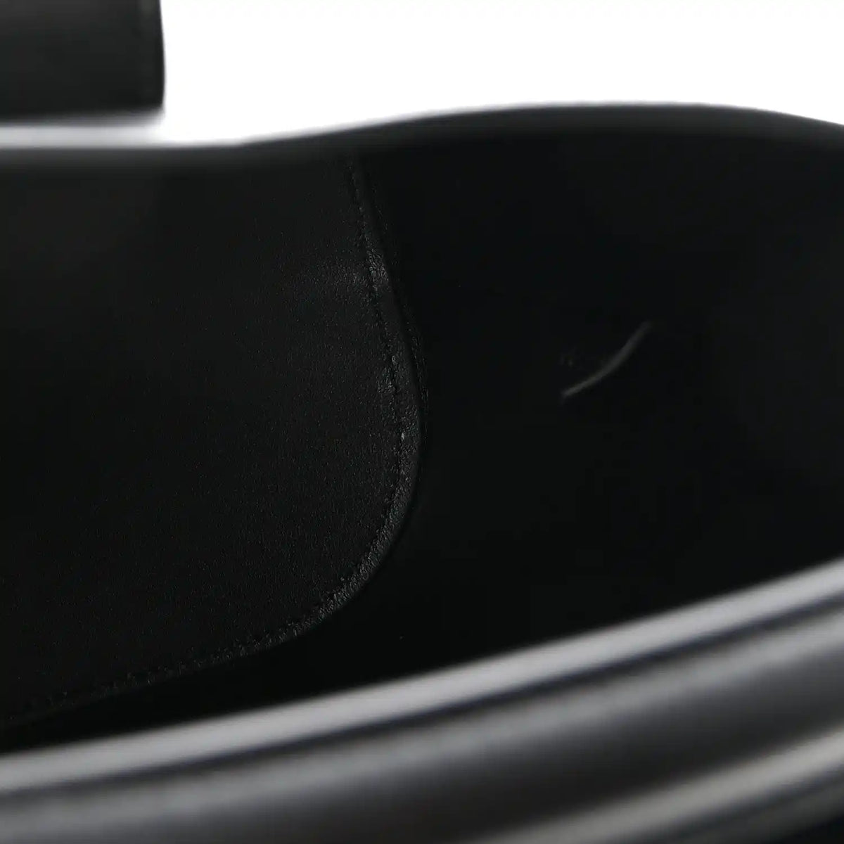 Close-up of smooth black leather bag panel with neat stitching seam