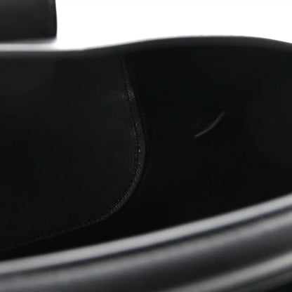 Close-up of smooth black leather bag panel with neat stitching seam