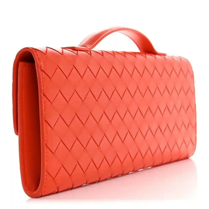 Orange intrecciato nappa clutch side view with top handle and woven texture