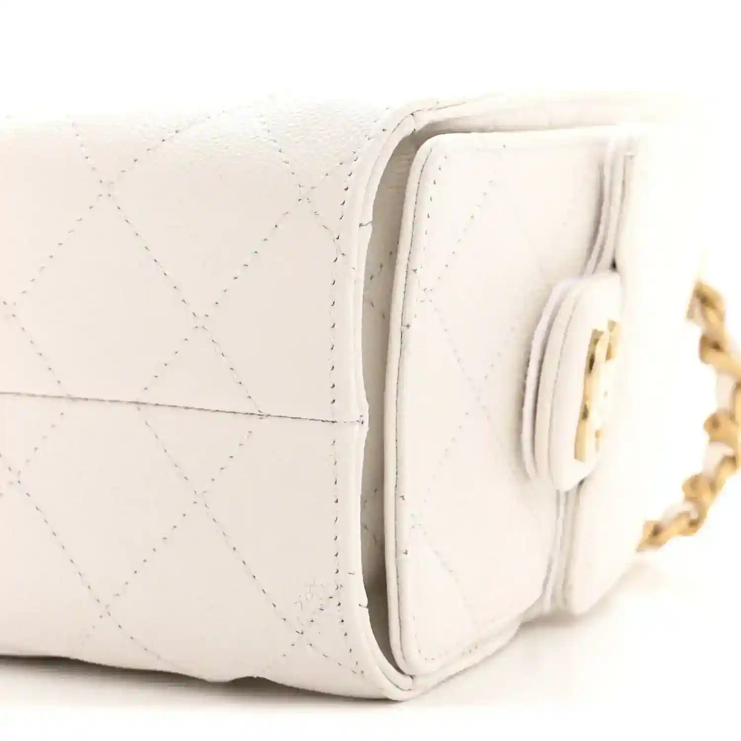 White quilted mini handbag side view with gold hardware and chain strap