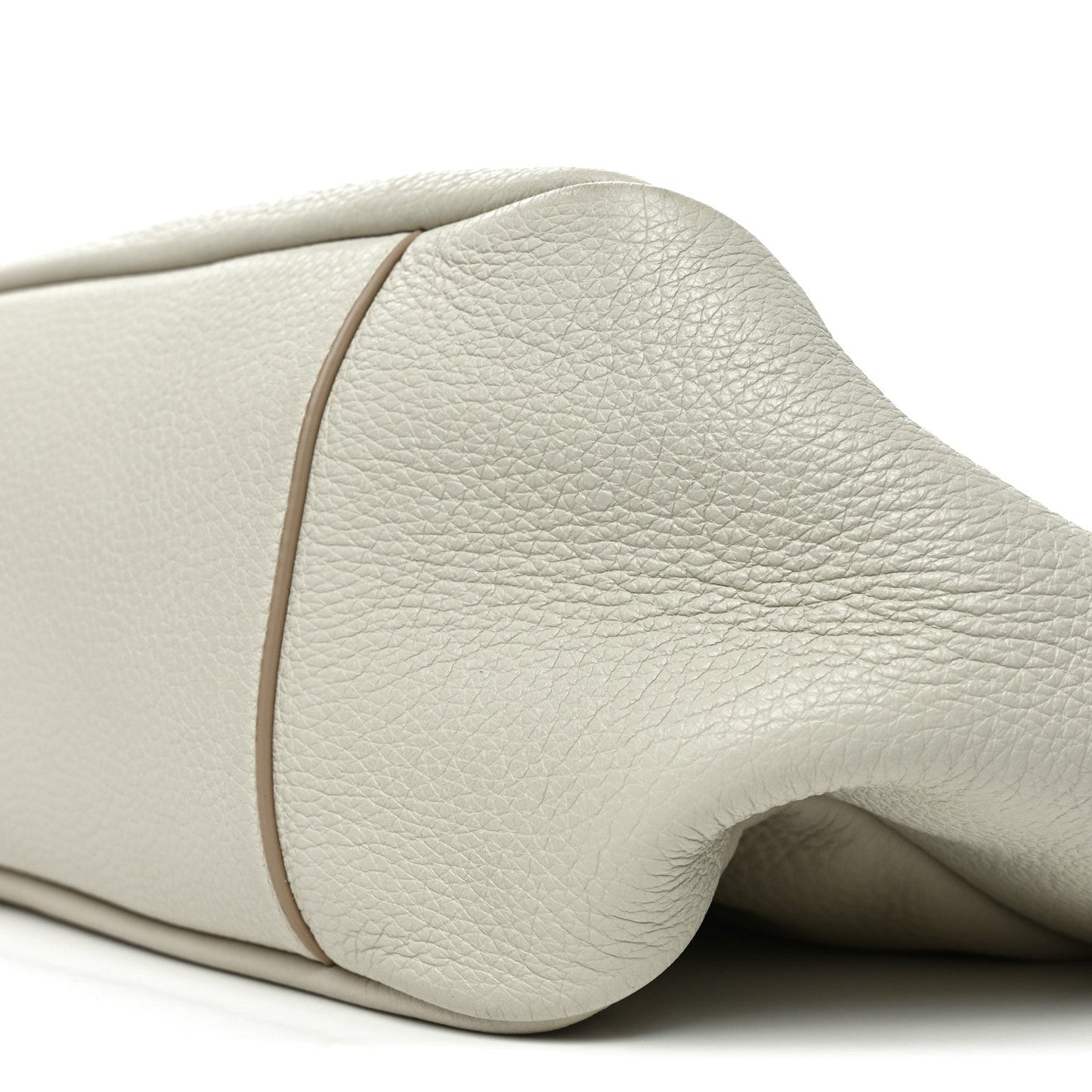 Close-up of white grained leather tote bag rounded side and seam edge