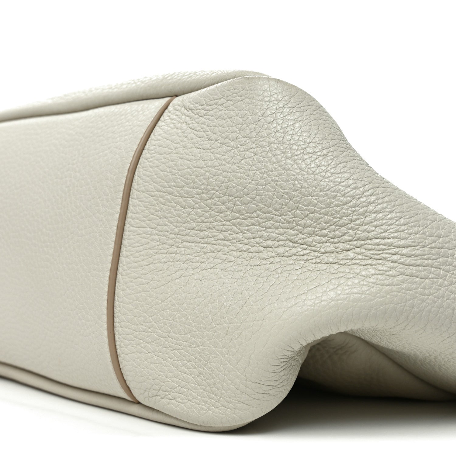 Close-up of white grained leather tote bag rounded side and seam edge