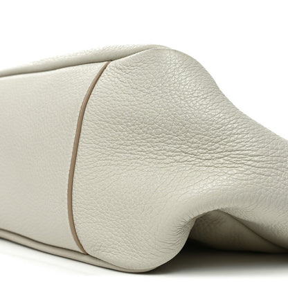 Close-up of white grained leather tote bag rounded side and seam edge