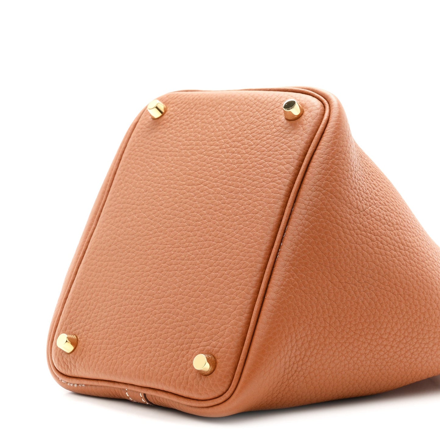 Tan leather bucket bag close-up with gold-tone corner studs and curved sides