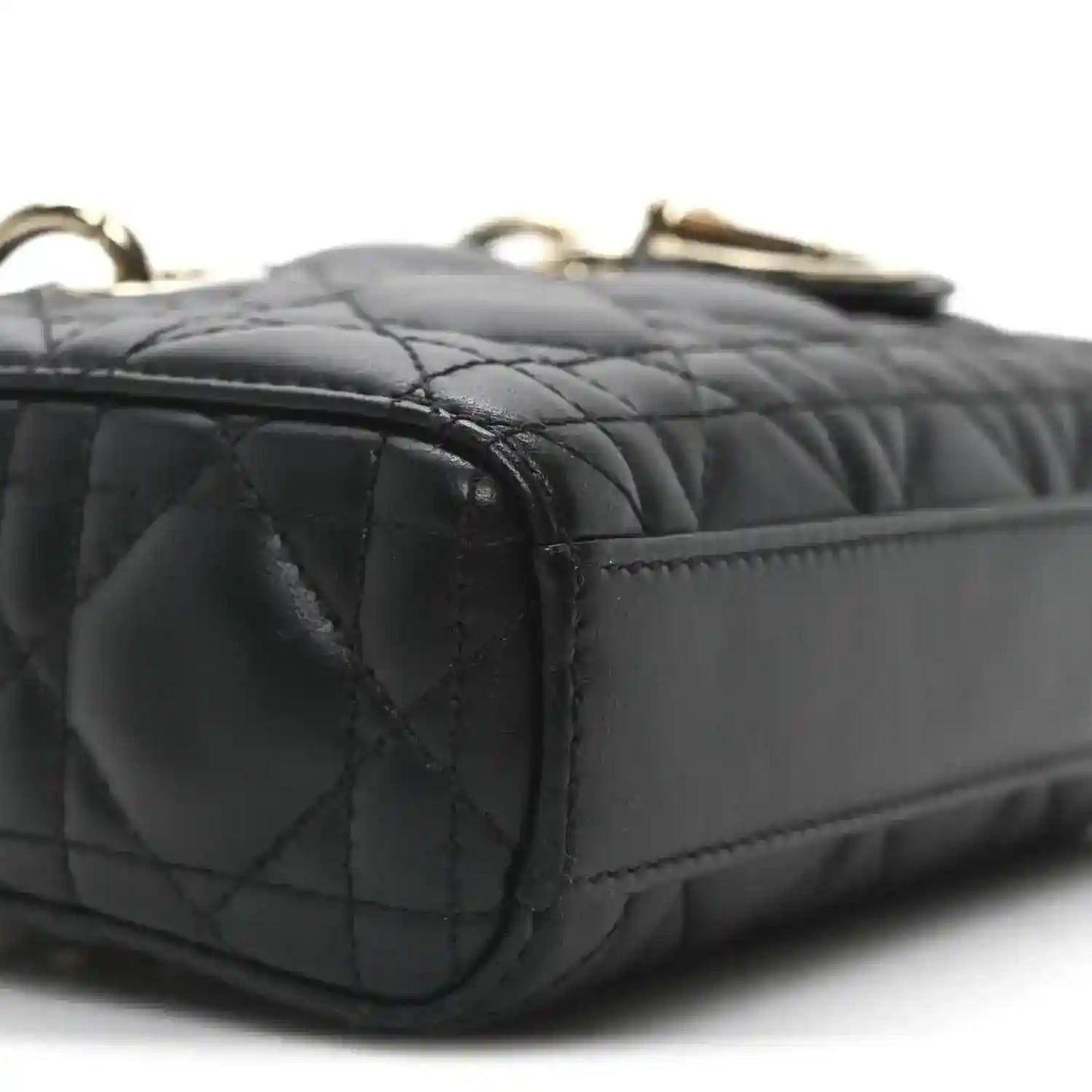 Black quilted mini handbag side with stitched panels and gold-tone top hardware