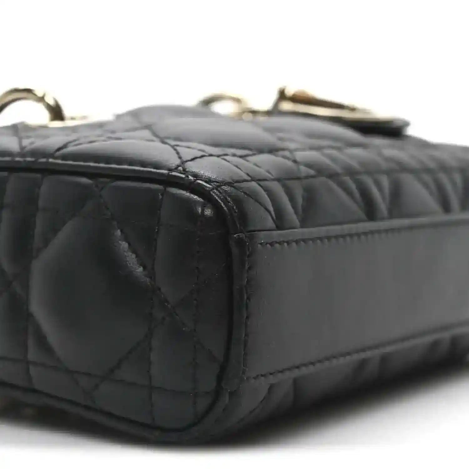 Black quilted mini handbag side with stitched panels and gold-tone top hardware
