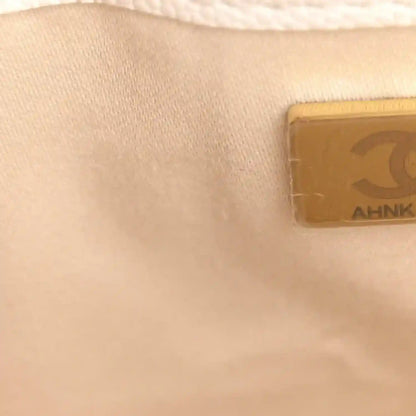 Small rectangular logo patch inside a light leather mini handbag