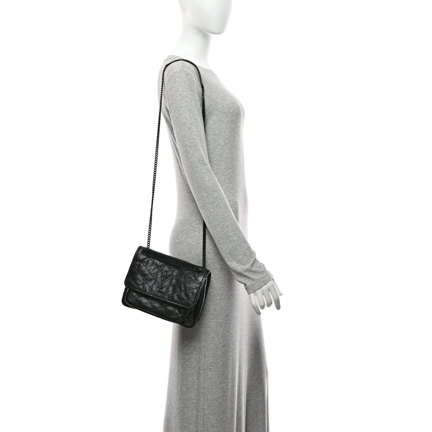Black mini satchel bag with chain strap and front flap on a small profile