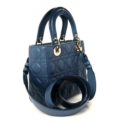 Small quilted indigo blue leather handbag with loop handles and side strap