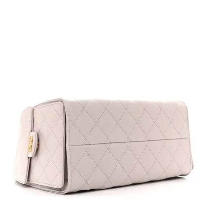 Lilac quilted mini handbag with front flap pocket and gold-tone hardware, structured shape