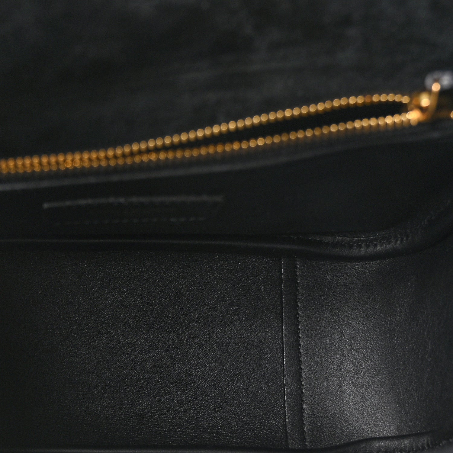 Black leather hobo bag interior edge with gold-toned zipper pull detail