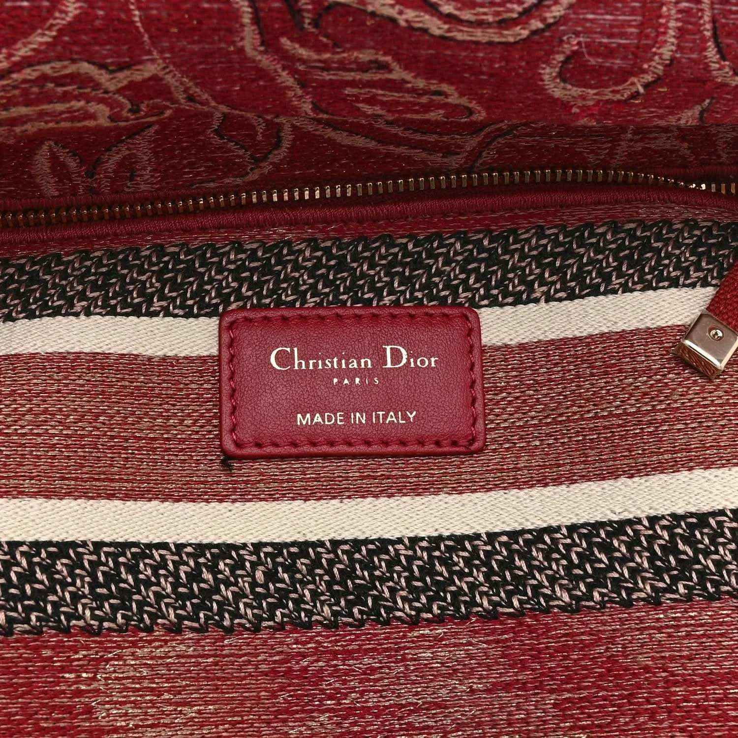 Red handbag label patch reading “Christian Dior Paris” and “Made in Italy”