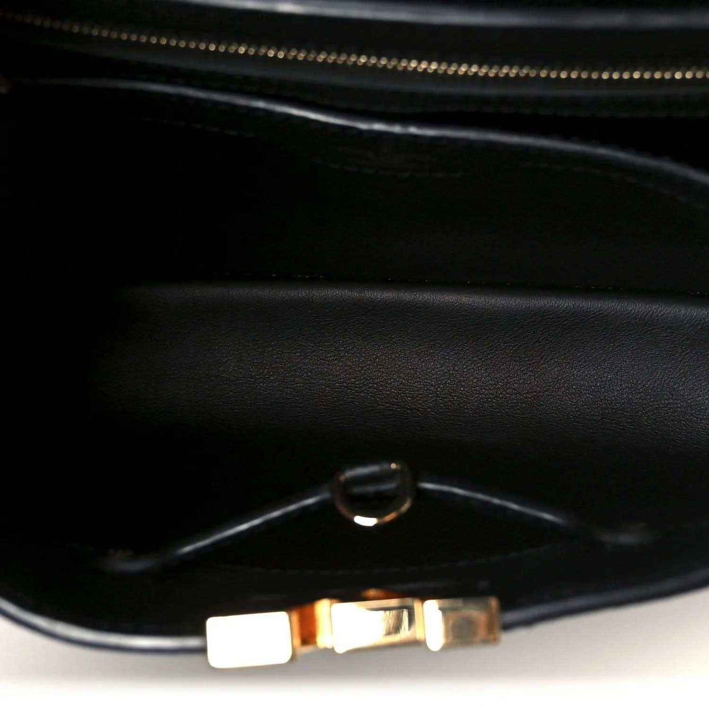 Black leather handbag interior with zipper and metal pull