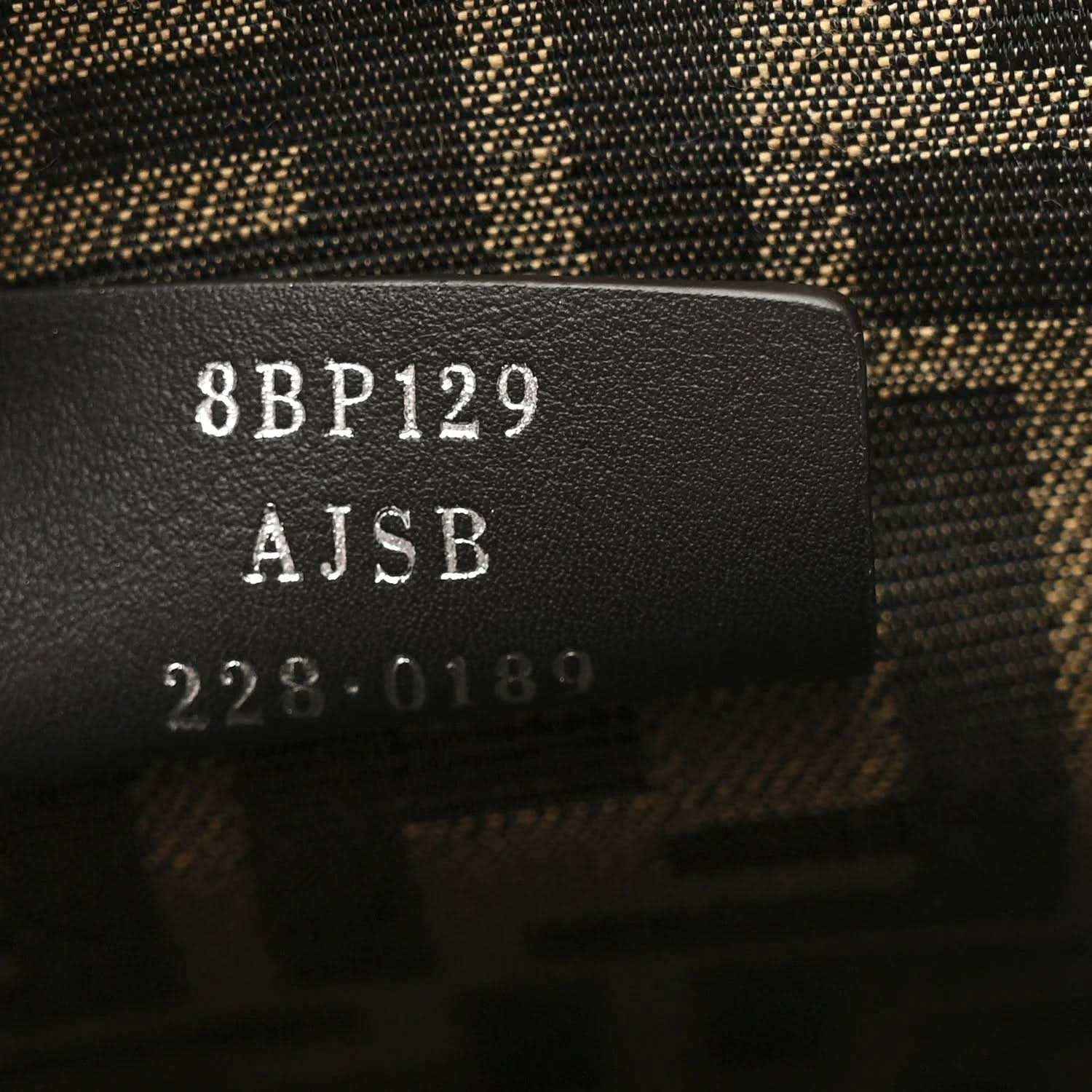 Clutch interior tag with “8BP129” and “AJSB” printed on leather