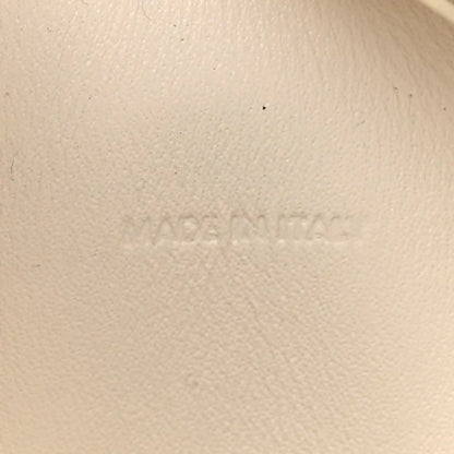 Light rice cream leather surface with faint embossed branding