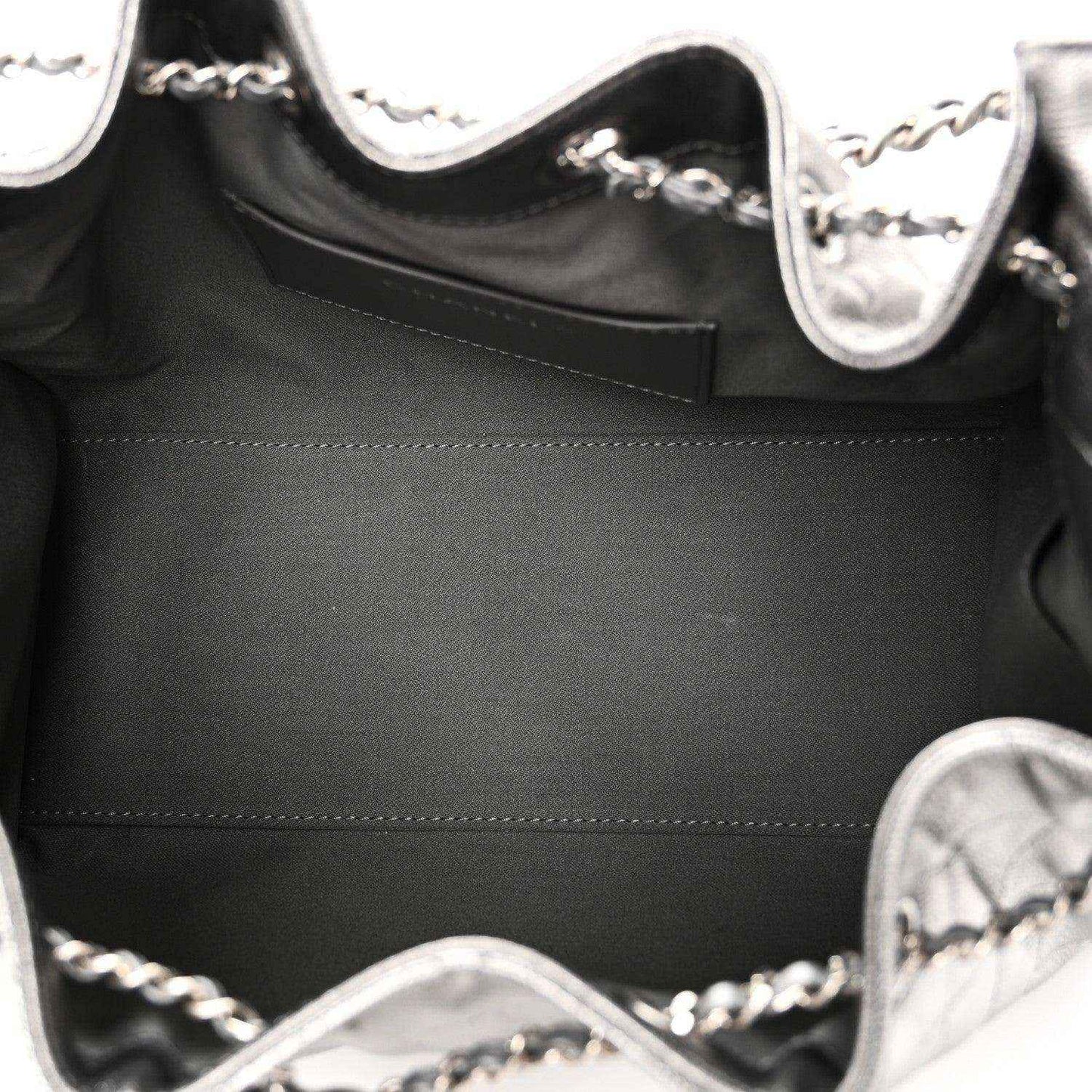 Chanel handbag interior close-up with black lining and silver chain strap