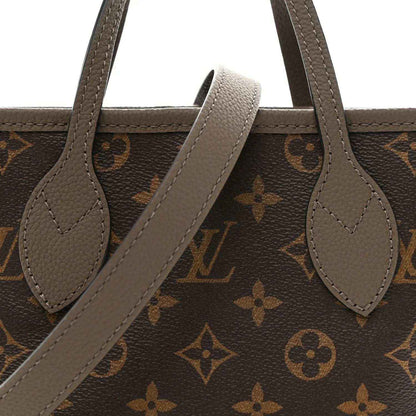 Dark monogram tote with gray leather handles and arched opening strap detail