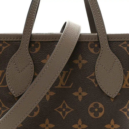 Dark monogram tote with gray leather handles and arched opening strap detail