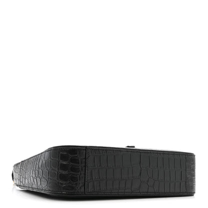 Black crocodile-embossed hobo bag, side view with wide base.