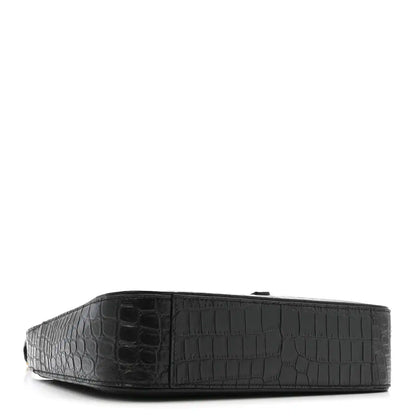 Black crocodile-embossed hobo bag, side view with wide base.